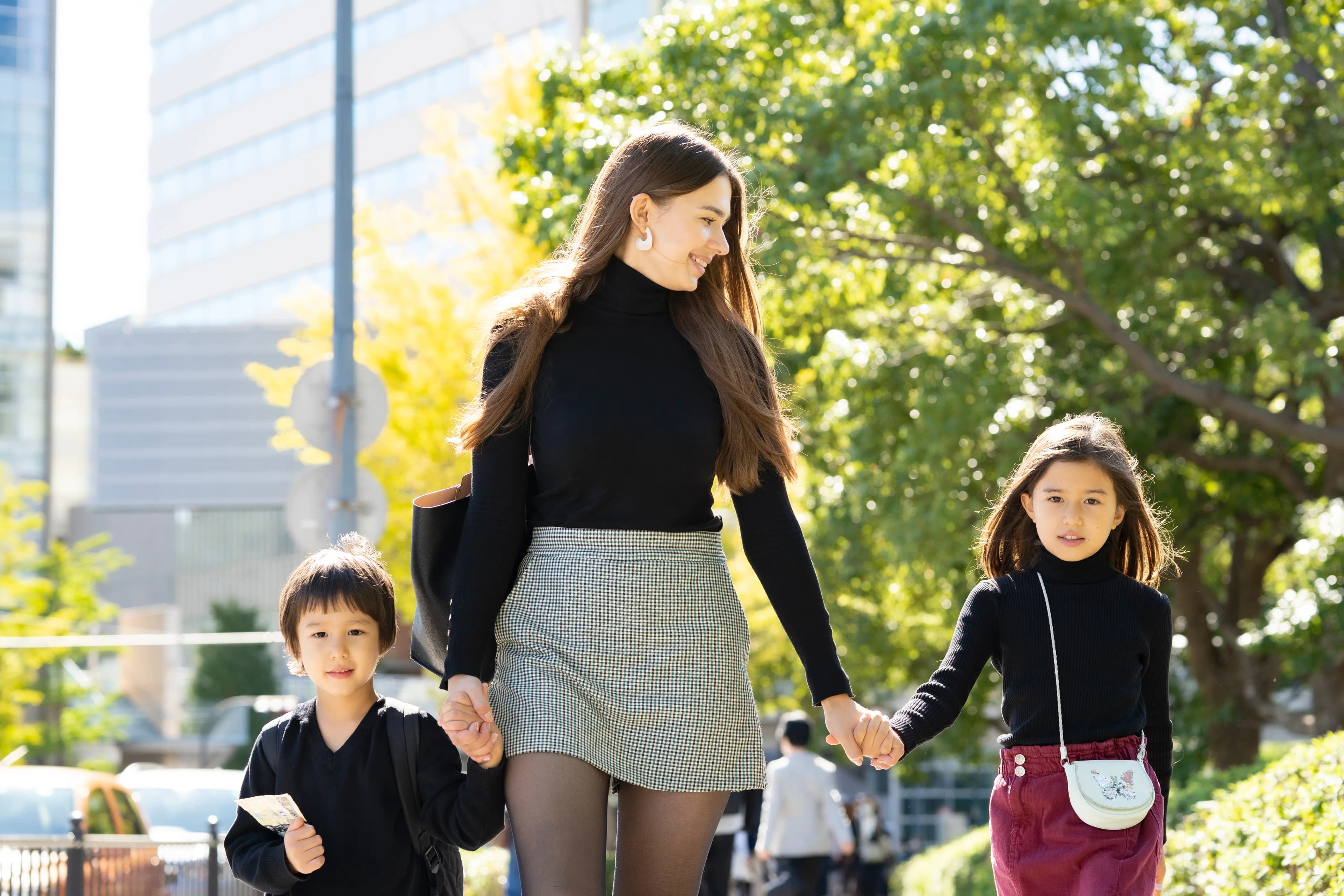 Woman walking with children in an urban setting